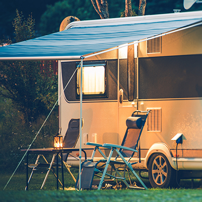 RV Camper with folding chairs in evening